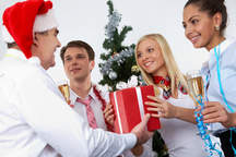 Chef übergibt seinen Mitarbeitern ein Geschenk (Weihnachtsfeier)
