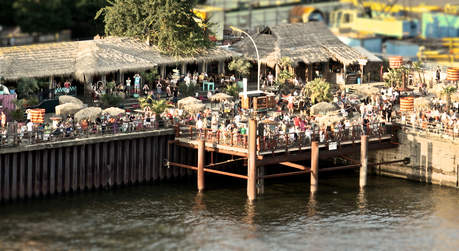 Internationale Gerichte und Cocktails im Restaurant, in Lounges oder auf Liegestühlen im Sand mit Hafenblick.