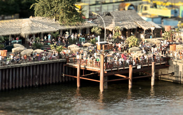 Internationale Gerichte und Cocktails im Restaurant, in Lounges oder auf Liegestühlen im Sand mit Hafenblick.