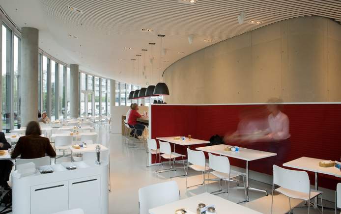 Restaurant mit Stehtischen und Pendelleuchten (nicht entfernbar) und weißen Sitzmöbeln (entfernbar)